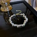 Close-up of irregular natural freshwater pearls showing lustrous texture on a gold chain. - Bracelet / Beige
