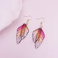 Close-up of elegant handmade butterfly wing earrings with glitter and crystal accents - Rhinestone Decoration / Champagne