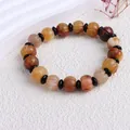Nahaufnahme der Texturen und Farben des kürbisförmigen Golden Silk Jade Perlenarmbands - Kürbis-Perle (12mm)