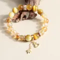 Close-up of natural yellow crystal and tiger eye beaded bracelet with star and heart charms - Tiger Eye & Yellow Tower Crystal Gourd Tassel Style