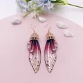 Elegante handgefertigte Ohrringe mit lila Schmetterlingsflügeln und glitzernden Kristallen - Roségold-Lila