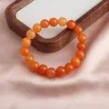 Detailansicht eines handgefertigten orangefarbenen Sonnenstein-Armbands auf Satin - 10mm Goldener Sonnenstein Stil / 10mm (ai-Einzelne Schlaufe)