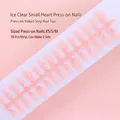 Detail view of 30-piece strip pink French press-on nails with heart patterns - Ice Translucent Pink Heart French Style (S081-T) / 30 Packs