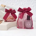 Detailed view of burgundy mesh gift bags with large satin bows holding perfume bottles - 9*12cm / Burgundy