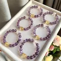 Collection of purple amethyst crystal bracelets on a grey velvet display tray - 10mm Bead Diameter / Purple