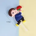 Detailed view of a 5.5cm cute boy cake topper holding red roses for birthday cake decoration. - Boy with Flowers