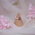 Detailed close-up of a natural freshwater pearl ring with strawberry quartz on a stand - Single Piece (Elastic) / Strawberry Quartz Style