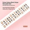 Gros plan de 30 faux ongles nude avec rayures noires et lignes galaxie argentées - Tailles Mixtes XS/S/M / Style à Rayures Diagonales Noires et Ligne Argentée Nude (S120-T) / Pack de 30