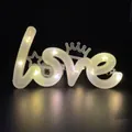 Primer plano de una lámpara LED Love blanca cálida para decorar pasteles y eventos - Love warm white light