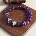 Close-up detail of 12mm natural amethyst beads and silver spacers on wooden base - Amethyst Bracelet