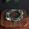 Close-up of double-strand dark green beaded bracelet with a single white pearl accent. - Double Wrap Bracelet / Blue Jade Color