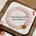 Elegantes rosa Quarz-Perlenarmband mit einem rötlichen Akzent und goldenen Zwischenperlen. - Pfirsichblüten-Rosa-Stil / Rosa