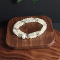 Macro view of a double-strand beaded bracelet with pale opal stones and a white pearl - Double Wrap Bracelet / Topaz Yellow