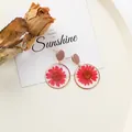 Élégantes boucles d'oreilles en résine avec de vraies marguerites rouges séchées. - Rouge