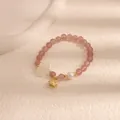 Dettaglio del bracciale con perline rosa con ciondolo a fiore e perla - Fortuna nella carriera