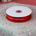 Gros plan sur un ruban en organza rouge avec texte imprimé Happy Birthday blanc - Imprimé Happy Birthday / Rouge