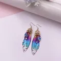 Elegante schillernde Schmetterlingsflügel-Ohrringe mit Kristallen und Goldakzenten. - Gold - Regenbogen Strass