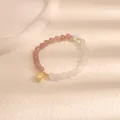 Primo piano di un braccialetto di perle con quarzo fragola e perle stile giada bianca. - Cappello Ufficiale