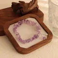 Natural amethyst chip bracelet with carved charm on a wooden tray - Amethyst Gravel Bracelet