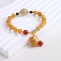 Nahaufnahme eines Perlenarmbandes aus Xinjiang-Goldsid-Jade mit einem Naturbutterkürbis-Anhänger. - Alles Gelbe Rundperle Mit Flaschenkürbis