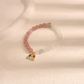 Elegante braccialetto di perline rosa e bianche con un ciondolo arcobaleno scintillante. - Arcobaleno