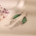Close-up of green cicada wing earrings with colorful crystals and silver frames. - Silver Frame / Dark Green