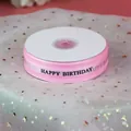 Gros plan sur ruban organza rose Happy Birthday pour décoration de gâteau et cadeaux. - Imprimé Happy Birthday / Rose