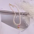 Detailansicht der Süßwasserperlenkette mit rosa Zirkonia-Anhänger auf Spiegel - Rosa Strass-Tropfen-Stil / Gold