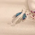 Detailed view of elegant blue butterfly wing earrings with shimmering iridescent crystals. - Silver Frame / New Blue