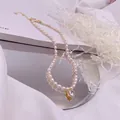 Nahaufnahme einer Süßwasserperlenkette mit Herz-Zirkon-Anhänger im Detail - Weißer Strass-Herz-Stil / Gold