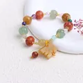Detailansicht eines ethnischen Xinjiang-Goldsid-Jade-Armbands mit bunten Kürbisperlen - Kürbisperle Glocke Mit Pixiu