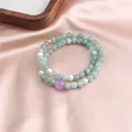 Detail view of a double-strand bracelet with light green jade and purple amethyst. - Double Loop Style / Blue Jade