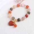 Nahaufnahme eines Perlenarmbands im Ethno-Stil mit geschnitzten Perlen und Anhänger - Goldener Jade-lotusperlen-anhänger Mit Friedensverschluss