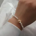 Gros plan d'un bracelet en perles baroques avec fermoir à bascule fleur dorée - Perle baroque naturelle / Style Fermoir Fleur