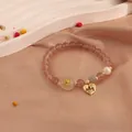 Close-up of elegant strawberry quartz bracelet with freshwater pearl and golden heart charm - Cupid Heart Style