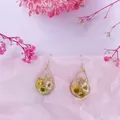 Vista detallada de pendientes de gota con flores secas naturales amarillas y blancas. - 11# Lágrima Blanco Amarillo Flor Seca Lámina de Oro
