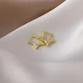 Close-up detail of gold-plated star-shaped hoop earrings on elegant silk fabric. - 8# 16428 Star Shape / Gold