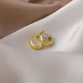 Detailed macro view of small polished gold hoop earrings on elegant silk satin fabric - 9# 16429 Wide Band / Gold