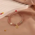 Detailed view of natural strawberry quartz beaded bracelet with freshwater pearl and gold charm. - Fu Character Style
