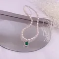Detailansicht einer eleganten Reisperlenkette mit einem grünen Zirkonia-Anhänger - Grüner Strass-Tropfen-Stil / Silber