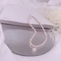 Detailansicht einer Süßwasserperlenkette mit funkelndem herzförmigem Zirkonia-Anhänger - Weißer Strass-Tropfen-Stil / Silber