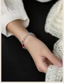 Elegant natural grey moonstone beaded bracelet featuring a red accent bead shown on wrist - Cinnabar-Moonstone