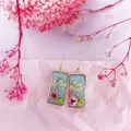 Vista detallada de pendientes rectangulares hechos a mano con flores secas reales y pan de oro. - 19# Rectángulo Rosa Verde Flor Seca Gancho