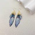 Elegante Ohrringe mit Schmetterlingsflügeln in Blau und glitzernden Steinen - Gold - Graublauer Strass