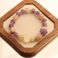 Elegant 12mm natural amethyst and rutilated quartz beaded bracelet on a wooden tray - Amethyst Super Seven Bracelet