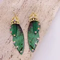 Detailed macro view of green cicada wing earrings featuring glitter and iridescent stones - Gold Hook / Dreamy Green