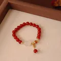 Exquisites Detail eines Armbands aus roten Achatperlen mit weißer Jade und Fu-Anhänger - Naturstein Roter Achat Chalcedon Pixiu Stil