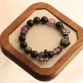 Close-up of 12mm natural amethyst and black obsidian bead bracelet with crystal bow charm - Rhinestone Bow Butterfly Pendant Style / Purple and Black