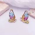 Vista macro de pendientes de ala de mariposa con brillantes diamantes de imitación - Base dorada / Arcoíris