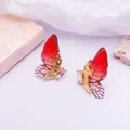 Detalle de elegantes pendientes de ala de mariposa rojo degradado con cristal brillante - Estilo Hoja de Oro / Rojo